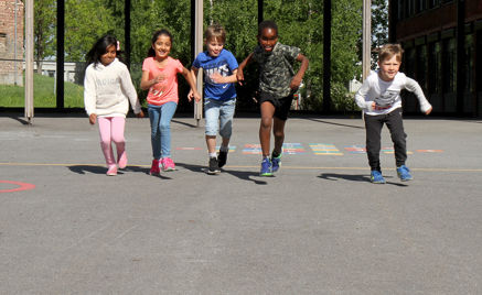 Barn som løper i skolegård