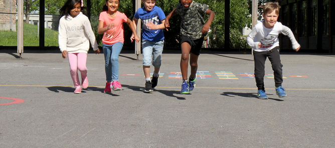 Barn som løper i skolegård