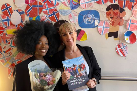 to personr som står foran en vegg med kunst