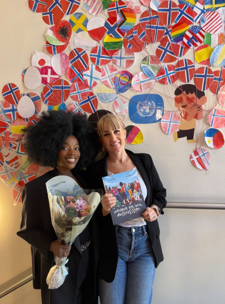 to personr som står foran en vegg med kunst